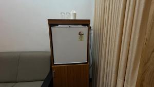 a white refrigerator in a stand next to a couch at ART Marari Beach house in Mararikulam