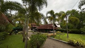 a small house in a yard with palm trees at ART Marari Beach house in Mararikulam