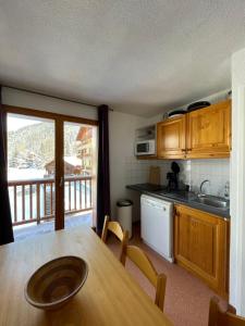 a kitchen with a table and a view of a balcony at Panorama Valfréjus in Modane
