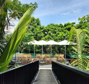a walkway with chairs and umbrellas at a resort at hiddenwoods in Bang Chak
