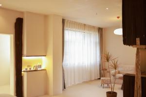 ein Wohnzimmer mit einem Fenster und einem Stuhl in der Unterkunft YSN Hill Breeze Retreat 云山南 玉龙雪山园林观景酒店 丽江古城束河白沙古镇店 in Lijiang + 72 Fotos