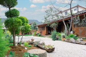 ein Garten vor einem Haus in der Unterkunft YSN Hill Breeze Retreat 云山南 玉龙雪山园林观景酒店 丽江古城束河白沙古镇店 in Lijiang