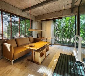 a living room with a couch and a table at hiddenwoods in Bang Chak