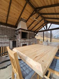 a large wooden table in a pavilion with a fireplace at Ascape Kabin in Broşteni +26 photos