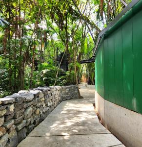 a stone wall and a sidewalk next to a fence at hiddenwoods in Bang Chak