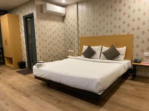 a bedroom with a large bed with white sheets at SwagStay Hotel OwnHouse 181 Nagpur in Nagpur