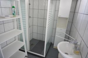 a bathroom with a shower and a toilet and a sink at Kustverhuur, Huuske Groede, pittoresk huisje vlakbij zee in Groede