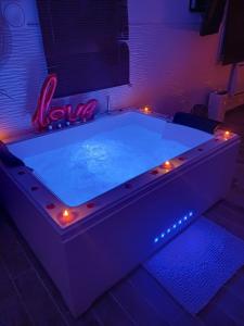 a large pool with lights in a room at Loft avec jacuzzi illimité et privatif au calme 20 min Paris in Saint-Prix