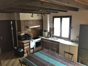 a kitchen with a sink and a stove top oven at Maison Lac de Pareloup -LES PIEDS DANS L'EAU- in Arvieu