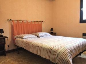 a bedroom with a bed with an orange curtain at Maison Lac de Pareloup -LES PIEDS DANS L'EAU- in Arvieu