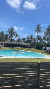 a swimming pool in a park with palm trees at Casa Bali Tofo in Praia do Tofo