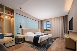 Postel nebo postele na pokoji v ubytování Echarm Hotel Wuhan Optics Valley Software Park Juran Home