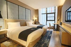 Postel nebo postele na pokoji v ubytování Echarm Hotel Wuhan Optics Valley Software Park Juran Home