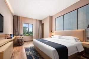 Postel nebo postele na pokoji v ubytování Echarm Hotel Wuhan Optics Valley Software Park Juran Home