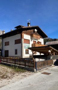 a building with a wooden fence in front of it at Appartamento Canes in Caviola