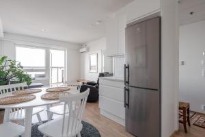 a kitchen and dining room with a table and a refrigerator at Modern 1BR Apt with Amazing Views, Balcony & Sauna in Tampere +26 photos