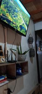 a flat screen tv hanging from a wall at Boresta House -Santa Elena con vista al Bosque y terraza privada in Medellín