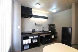 a kitchen with a sink and a black refrigerator at 6名泊まれて鼓動を感じるシティウォークの拠点に-voyage- in Kumamoto