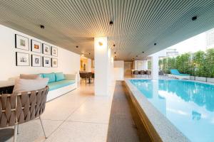 a house with a swimming pool and a living room at The One Cozy Living in Pattaya