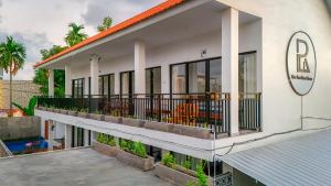 a building with a balcony with chairs on it at Rice Fera Guest House in Canggu