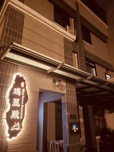 a building with a sign on the side of it at 瑪麗殿民宿 in Jinning