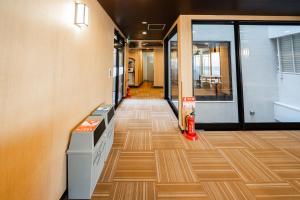 an office hallway with wooden floors and glass doors at E JOY INN-Higashi Nipoori in Tokyo