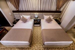 Postel nebo postele na pokoji v ubytování Cairo Taj Hotels & Suites- Mohandessin
