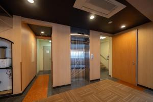 a hallway with wooden walls and glass doors at E JOY INN-Higashi Nipoori in Tokyo