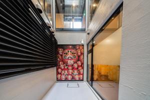 a hallway with a painting on the wall in a building at E JOY INN-Higashi Nipoori in Tokyo +14 photos
