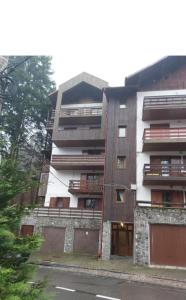Un edificio de apartamentos con un estacionamiento enfrente. en George Apartament Central cu gradina proprie, en Sinaia