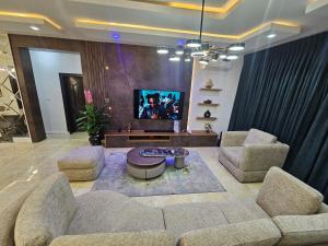 a living room with two couches and a tv at Genesis Grid Homes - Petra in Lekki