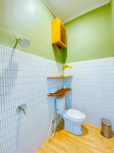 a bathroom with a toilet and a tv on the wall at Villa Ganesh by Suasana Villa in Jarakan +8 photos