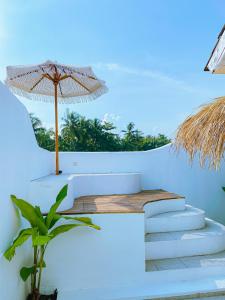 a staircase with an umbrella on a white wall at Villa Ganesh by Suasana Villa in Jarakan