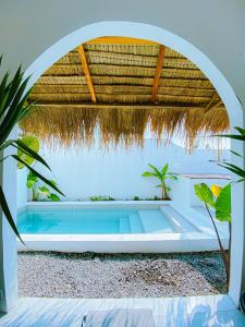 a swimming pool under an arch with a straw roof at Villa Ganesh by Suasana Villa in Jarakan