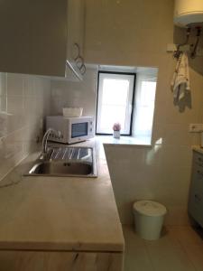 a small kitchen with a sink and a microwave at Shabby Chic Flat 2 in Lisbon