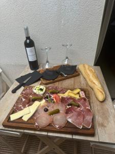 a cutting board with meat and cheese and wine glasses at Le cocon de sissy in Saintes-Maries-de-la-Mer