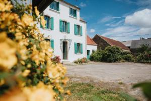 a white house with green shutters on it at La Maison Trèfle - Entre terre et mer - 3 chambres et 4 lits double in Kerlouan