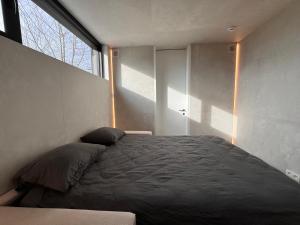 a bedroom with a bed and a large window at The Box in Sint-Pieters-Leeuw