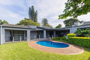 a house with a swimming pool in the yard at 8 On Eagle Bed & Breakfast Room 1 in Umtentweni