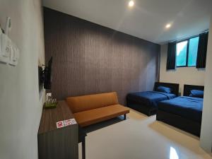 a small room with two beds and a couch at BnB Home in Blimbing