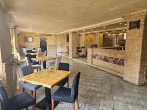 un ristorante con tavoli e sedie in legno e bancone di Prenociste Rooms Simke a Subotica