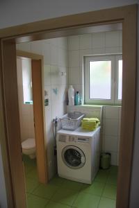 a bathroom with a washing machine and a toilet at Atrium serviced Apartments and Bungalows in Herzogenaurach +44 photos