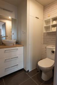 a bathroom with a white toilet and a sink at La Parenthèse - Studio près de la Petite France in Strasbourg