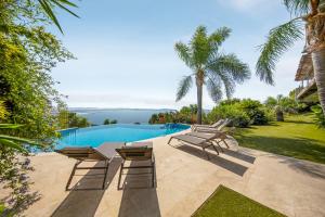 a patio with chairs and a swimming pool at Prestigieuse Villa Piscine vue mer-WiFi CLiM By HC 4 chambres - vue mer époustouflante Parking-WIFI BY HC in Hyères