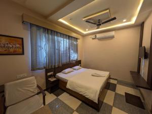 a hotel room with a bed and a window at Kishori Vatika in Rāmnagar