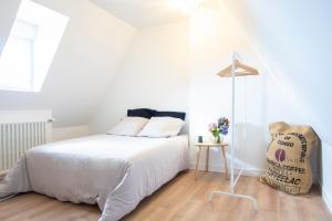 una camera da letto bianca con un letto e una sedia di Villa Confort I Terrain & Grande Terrasse a Crozon