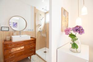 un bagno con lavandino e vaso di fiori viola di Villa Confort I Terrain & Grande Terrasse a Crozon
