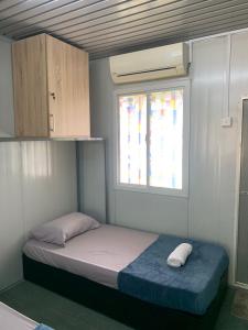 a small bed in a room with a window at Farhani Cabin Stay in Kampong Batu Lima +4 photos