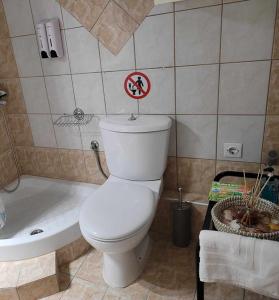 a bathroom with a toilet and a bath tub and a sign on the toilet at MarGe Apt in Arta +39 photos