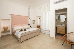 une chambre avec un grand lit et un miroir dans l'établissement I ricami di Annina, à Castellana Grotte